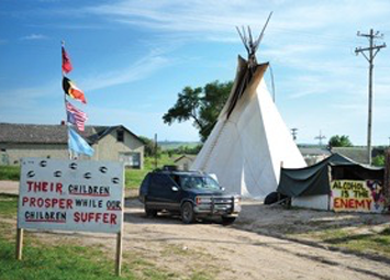 Camp Zero Tolerance: a Native American tent with protest signs